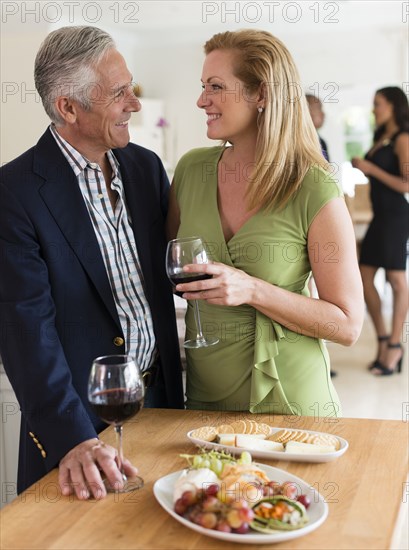 Caucasian couple drinking wine at party