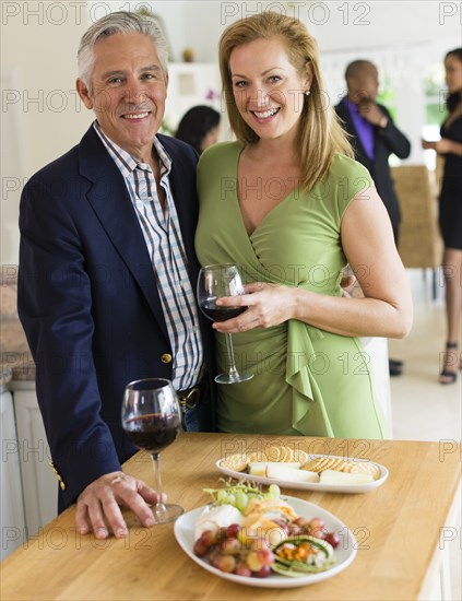 Caucasian couple drinking wine at party