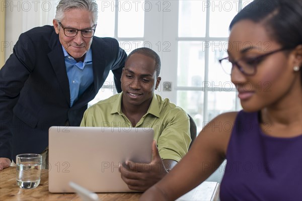 Friends using laptop at party