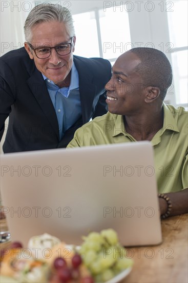 Businessmen using laptop at desk