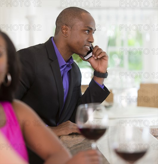 Man talking on cell phone at wine bar