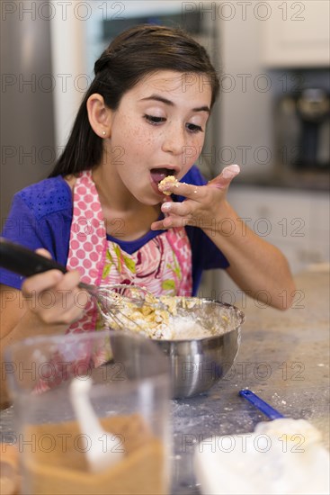 Mixed race girl baking in kitchen