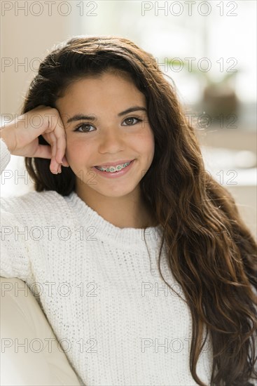 Mixed race girl smiling on sofa