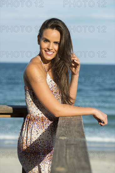 Hispanic woman standing on beach pier