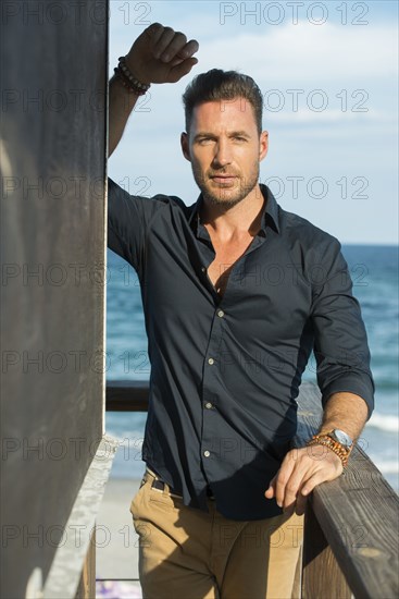 Caucasian man standing on beach pier