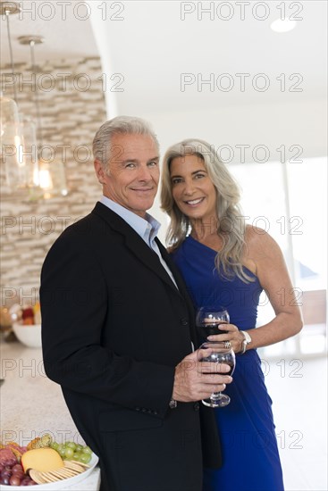 Caucasian couple drinking wine in kitchen