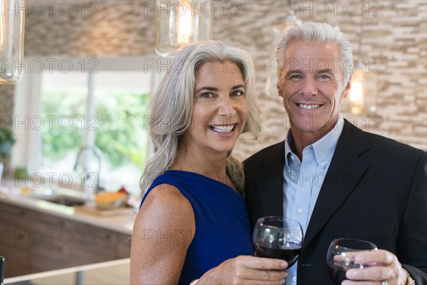 Caucasian couple drinking wine in kitchen