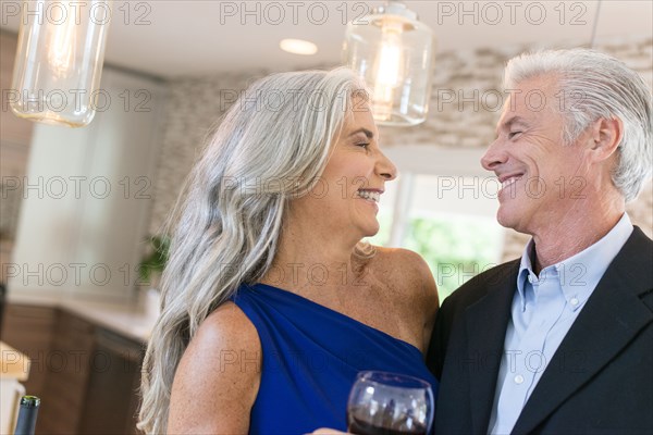 Caucasian couple drinking wine in kitchen