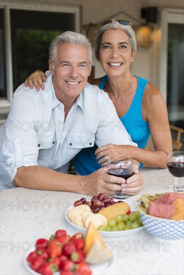 Caucasian couple drinking wine at table