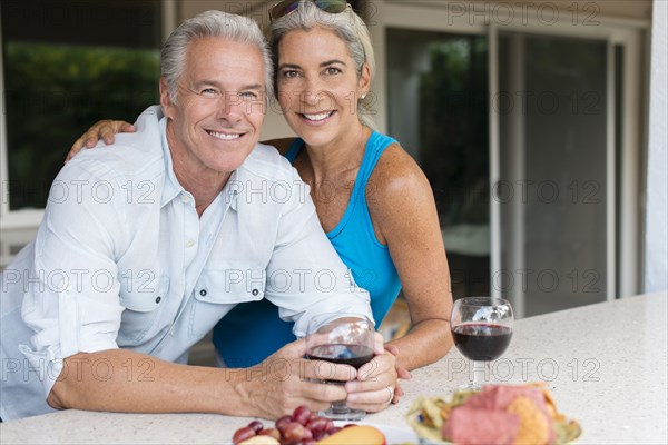 Caucasian couple drinking wine at table