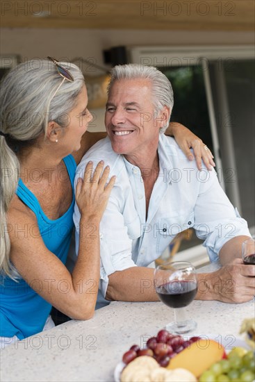 Caucasian couple drinking wine at table