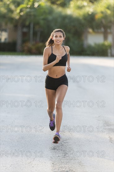 Mixed race teenage girl running outdoors