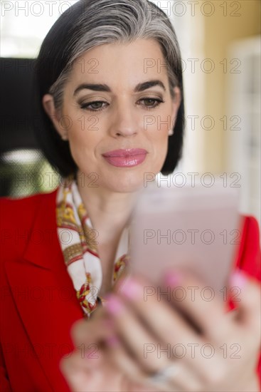 Caucasian businesswoman using cell phone in office