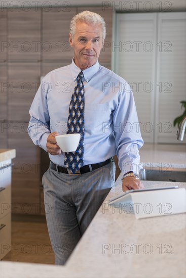 Caucasian businessman using digital tablet in kitchen