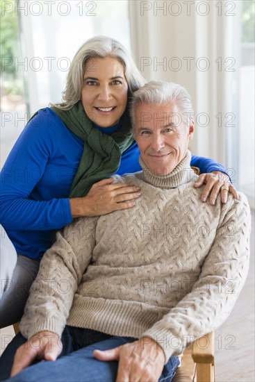 Caucasian couple hugging in armchair