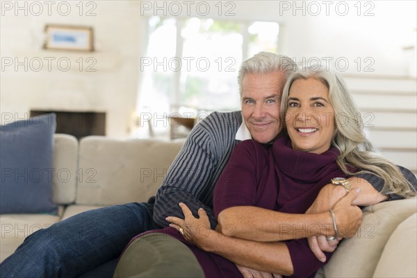 Caucasian couple hugging on sofa