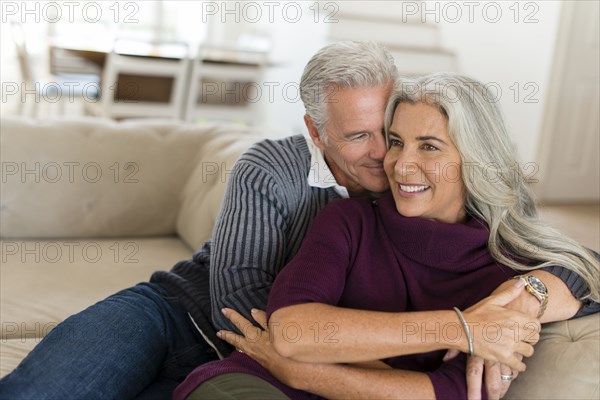 Caucasian couple hugging on sofa