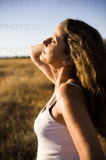 Hispanic woman standing in remote field