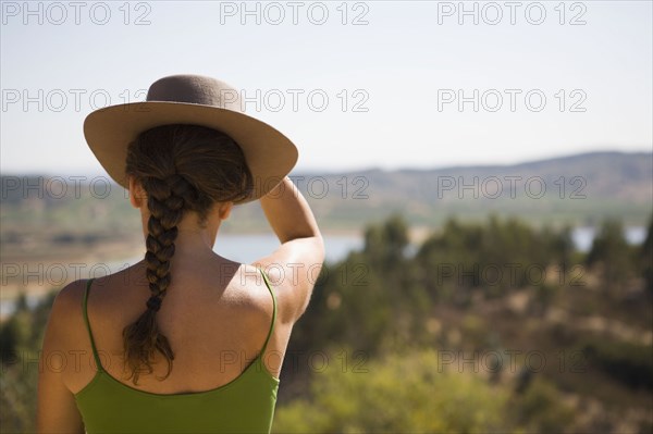 Hispanic woman in hat viewing remote landscape