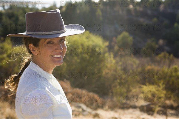 Hispanic woman wearing hat in remote location