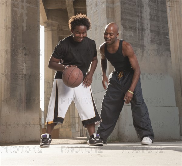 African father playing basketball with son