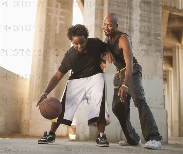 African father playing basketball with son