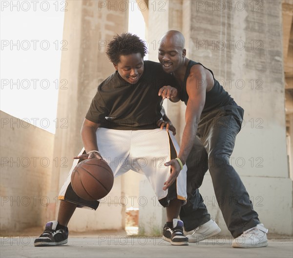 African father playing basketball with son