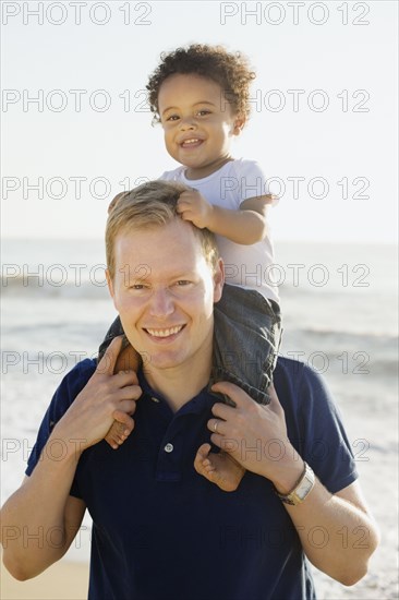 Caucasian father carrying mixed race son