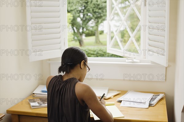 African woman writing at desk