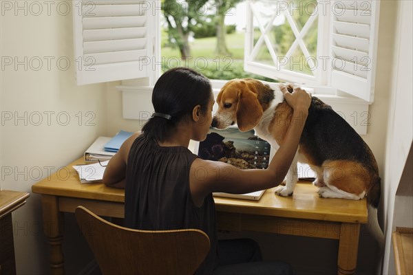 African woman at desk with dog