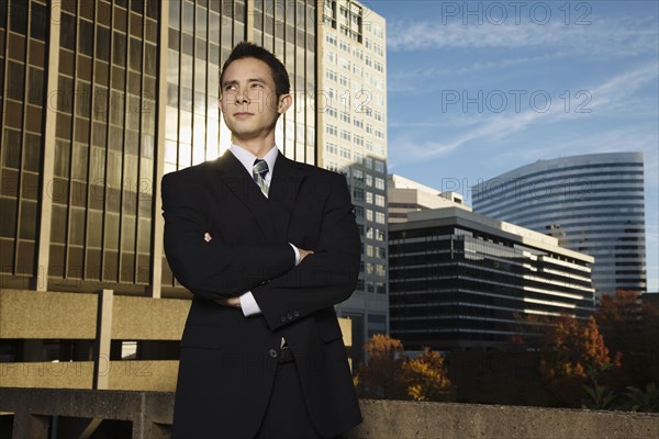 Mixed race businessman with arms crossed