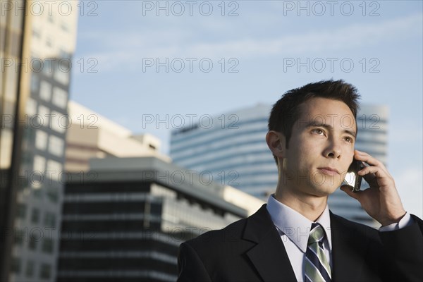 Mixed race businessman talking on cell phone