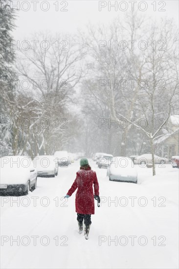 Caucasian woman walking in snow storm