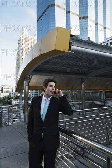 Caucasian businessman talking on cell phone outdoors