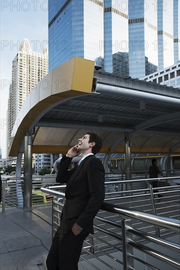 Caucasian businessman talking on cell phone outdoors