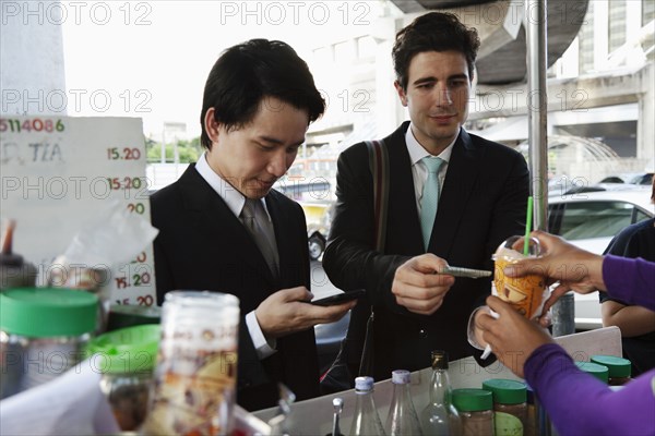 Businessmen buying lunch together at food cart