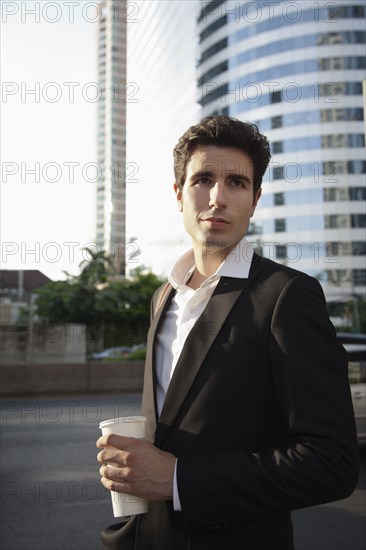 Caucasian businessman drinking coffee outdoors