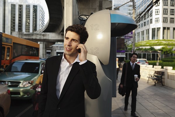 Caucasian businessman talking on cell phone outdoors