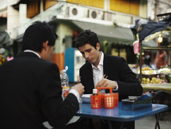 Businessmen eating lunch together outdoors
