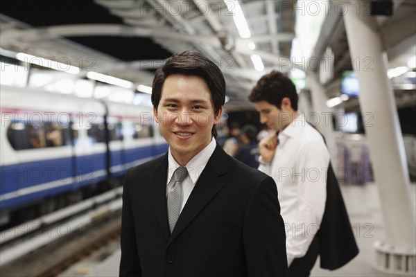 Businessmen waiting on platform for subway train