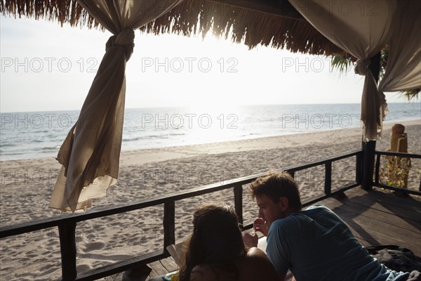 Couple laying on porch enjoying beach and ocean