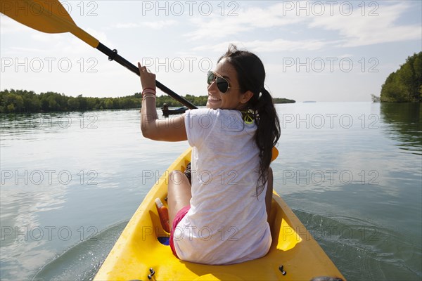 Hispanic woman paddling kayak