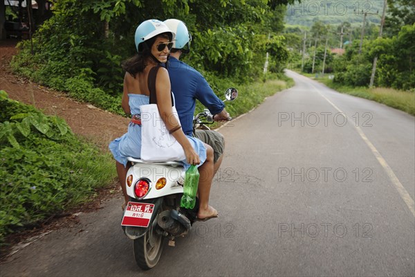 Couple riding scooter in remote area