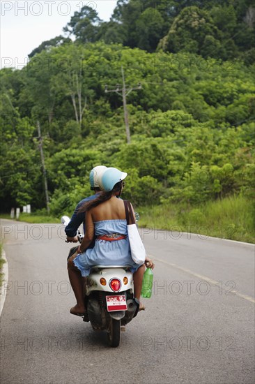 Couple riding scooter in remote area