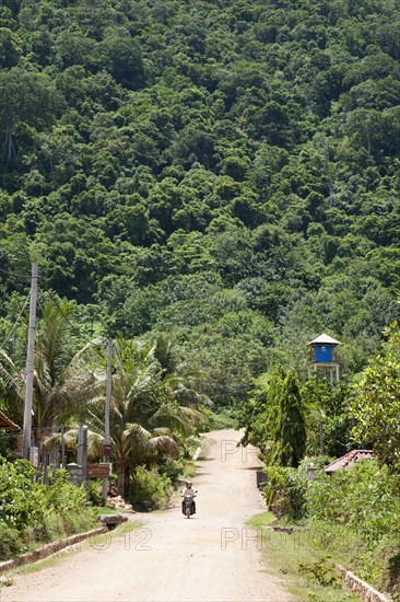 Person riding on scooter in remote Cambodian area