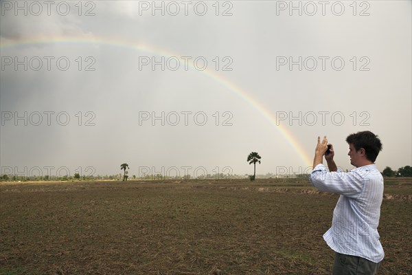 Man taking picture of rainbow