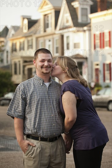 Caucasian woman kissing husband