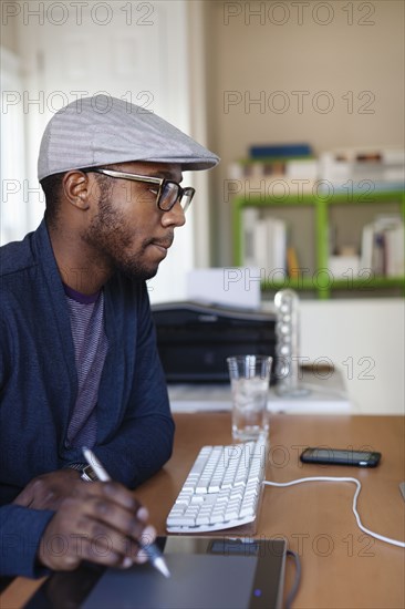 Black designer working at desk