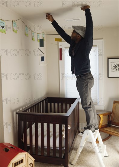 Black man decorating bedroom