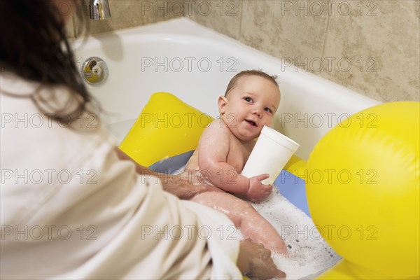 Caucasian mother bathing baby boy